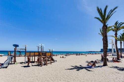 people on a beach with palm trees and a playground at Rambla 43 in Alicante