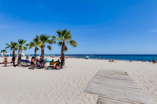 a group of people on a beach with palm trees at Rambla 43 in Alicante