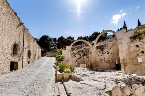 an alley in an old stone building with flowers at Rambla 43 in Alicante