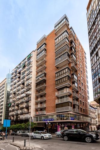 a tall building with cars parked in front of it at Rambla 43 in Alicante