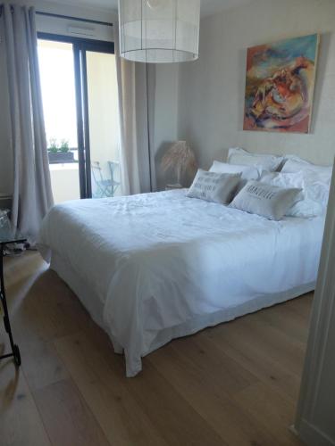 1 cama blanca grande en un dormitorio con ventana en Jolie chambre à louer - Vue Imprenable, en Lyon