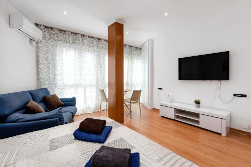 a living room with a blue couch and a tv at Rambla 43 in Alicante