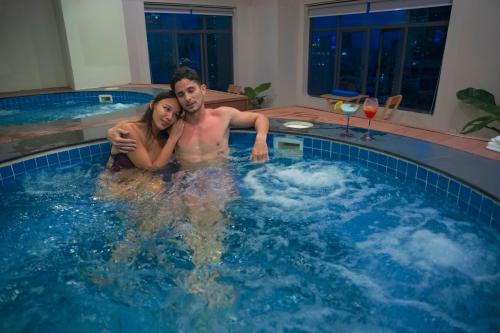 a man and a woman in a swimming pool at HM Grand Central Hotel in Phnom Penh