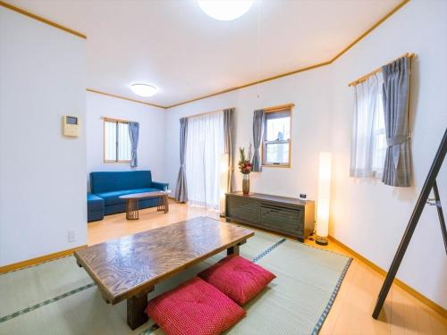 a living room with a table and a blue couch at Katsushika Takasago House in Tokyo