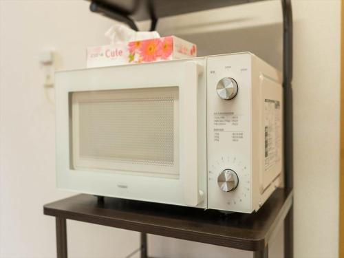 a microwave oven sitting on top of a table at Katsushika Takasago House in Tokyo