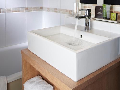 a white sink with a faucet in a bathroom at The White Swan in Arundel