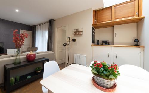 - un salon avec une table blanche et une plante dans l'établissement Ultra Centre Terrasse et Plage a Pied, à Le Touquet-Paris-Plage