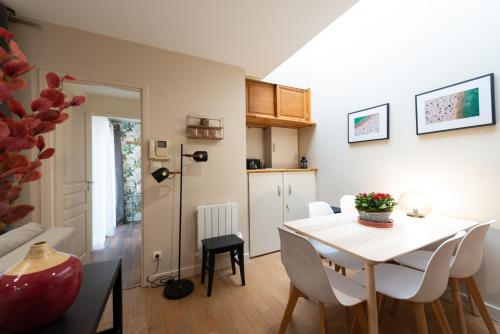 une cuisine et une salle à manger avec une table et des chaises blanches dans l'établissement Ultra Centre Terrasse et Plage a Pied, à Le Touquet-Paris-Plage
