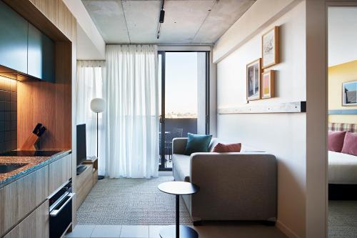 uma sala de estar com um sofá e uma mesa num quarto em Lanbruk Richmond Hill em Melbourne