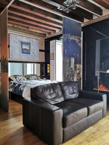 a bedroom with a bed and a leather couch at APARTAMENTo MADRID CENTRO GRAN VIA - CALLAO in Madrid