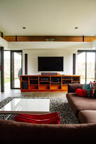 a living room with a couch and a flat screen tv at Collection Luxury Accomodation Simola House in Knysna