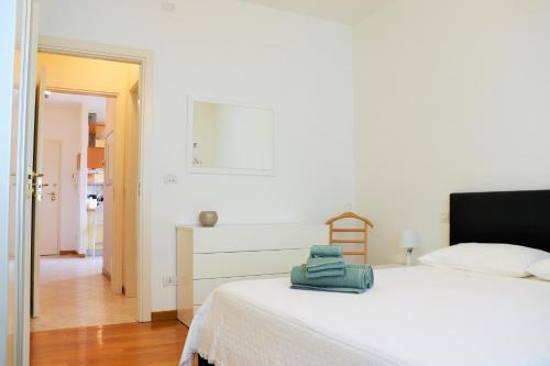 a white bedroom with a white bed and a hallway at Sweet Home San Lazzaro in San Lazzaro di Savena