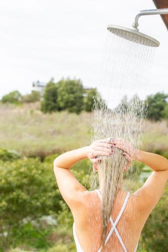 a woman is under a water fountain at Collection Luxury Accomodation Simola House in Knysna