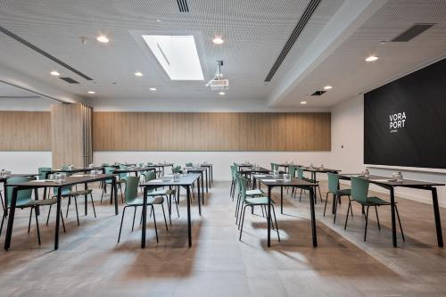 a dining room with tables and chairs and a chalkboard at Acta Voraport in Barcelona