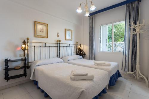 2 camas individuales en un dormitorio con ventana en CASA SAN CAYETANO, en La Herradura