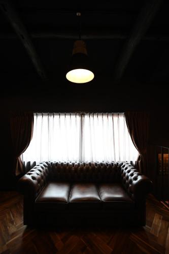 a leather couch sitting in front of a window at Inari Ohan in Kyoto