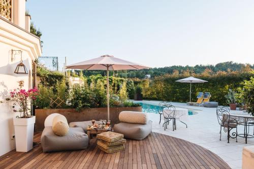 patio con tavolo, sedie e ombrellone di Villa Paradiso Charme&Design ad Arquata Scrivia