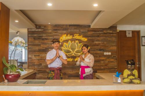 a man and a woman standing in front of a wall at Mahalaksmi Boutique Hotel in Sanur