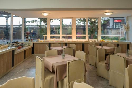 a restaurant with tables and chairs and a counter at Hermes Hotel in Kissamos