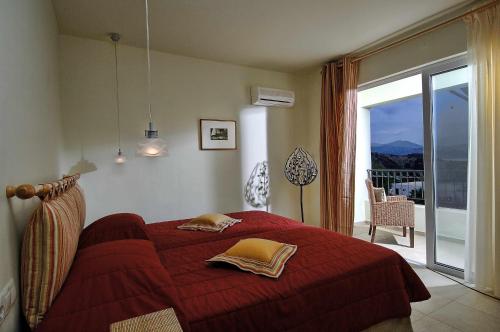 - une chambre avec un lit rouge et un balcon dans l'établissement Spacious villa with private pool and sea view, just 150 meters from the sea, à Istron
