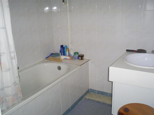 ein weißes Badezimmer mit einer Badewanne und einem Waschbecken in der Unterkunft residentie leopold ( 31 ) in Blankenberge