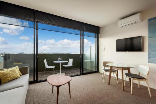 a living room with a couch and a table and chairs at Quest Frankston on the Bay in Frankston
