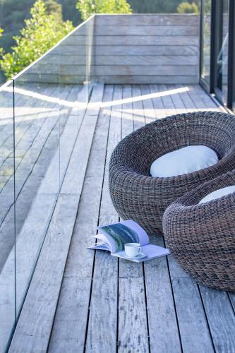 a wooden deck with a book and a cup and a bowl at Collection Luxury Accomodation Simola House in Knysna