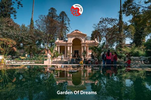 um jardim de sonhos com pessoas em pé em frente a um edifício em Hotel Holiday Taj (p) Ltd em Kathmandu