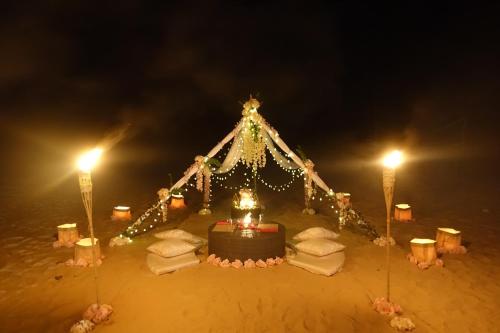 a tent in the sand at night with lights at Nacpan Beach Glamping Managed by H Hospitality Group in El Nido
