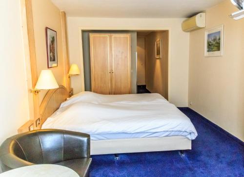 a hotel room with a bed and a chair at Hotel Pacific in Ostend