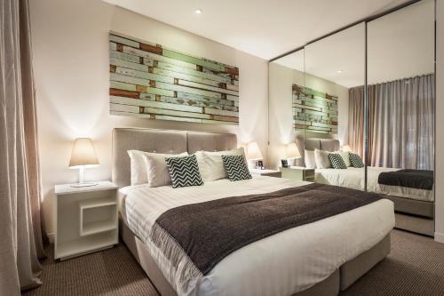 a bedroom with a large bed and a couch at Quest Frankston on the Bay in Frankston