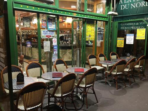 a row of tables and chairs in front of a restaurant at A la Pinte du Nord in Paris