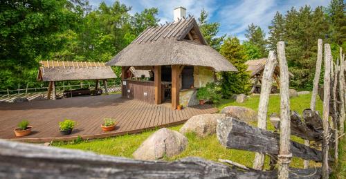 a small house with a thatched roof on a deck at Kassari Puhkekeskus in Käina
