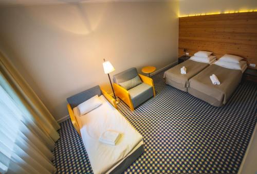 a hotel room with two beds and a chair at Kassari Puhkekeskus in Käina