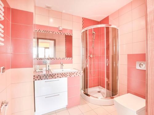 a pink bathroom with a shower and a sink at VacationClub – Osiedle Podgórze 1C Apartament 22 in Szklarska Poręba