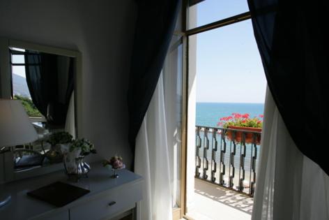 a room with a view of the ocean from a balcony at Grand Hotel Fagiano Palace in Formia