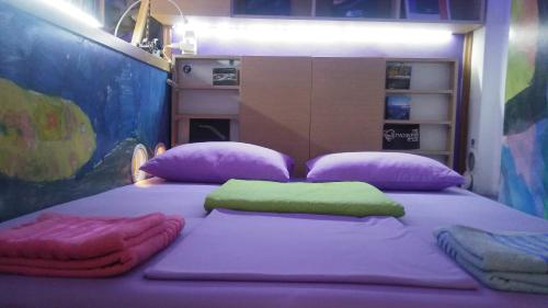 ein Bett mit lila und grünen Laken und Kissen in der Unterkunft Athens centre diamond in Athen