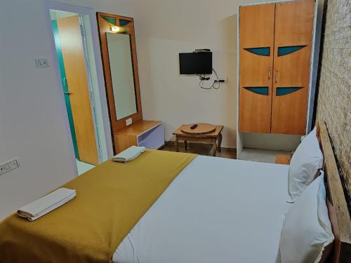 a room with a bed with a mirror and a door at Rajdhani Resort Lonavala in Lonavala