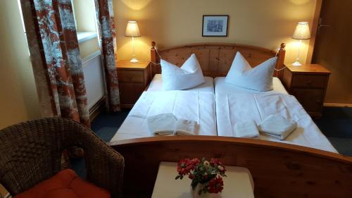 ein Schlafzimmer mit einem großen Bett mit weißer Bettwäsche und Kissen in der Unterkunft Pension Am Holzgraben in Lübbenau