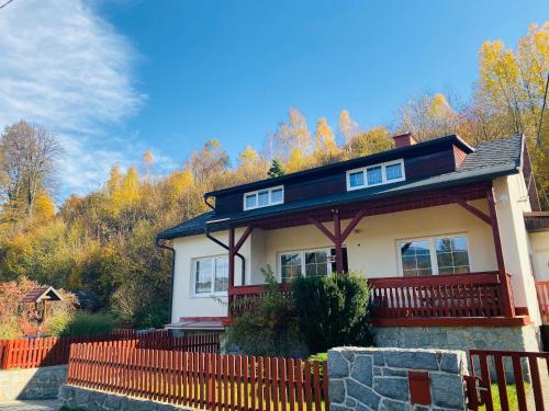 a house with a fence in front of it at Penzion U Rodinky in Bělá pod Pradědem