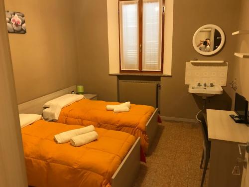 2 łóżka w małym pokoju z umywalką w obiekcie Albergo centrale w mieście Cortemaggiore