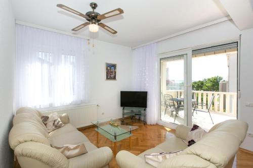 een woonkamer met twee witte banken en een televisie bij Apartment Angelina in Split