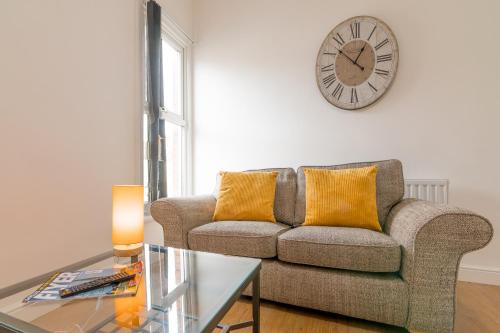 a living room with a couch and a clock on the wall at PLATFORM Fishing Quarter Apartment 2 in Hull
