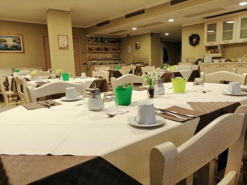 a dining room with white tables and white chairs at Agriturismo Al Palaz in Prata Camportaccio