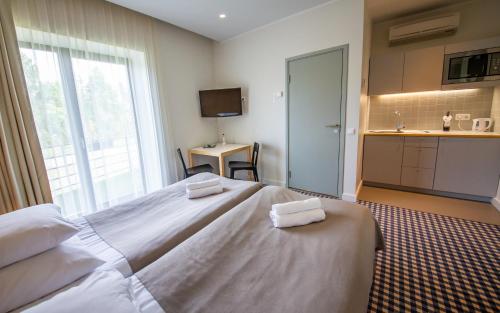 a bedroom with a large bed with two towels on it at Kassari Puhkekeskus in Käina