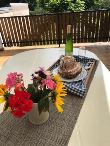 a table with a bottle of wine and a vase of flowers at Gite chez Annette et Pierre Weber in Niedernai