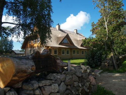 Tihuse Horsefarm B&B في Liiva: قطعة خشب أمام منزل بجدار حجري