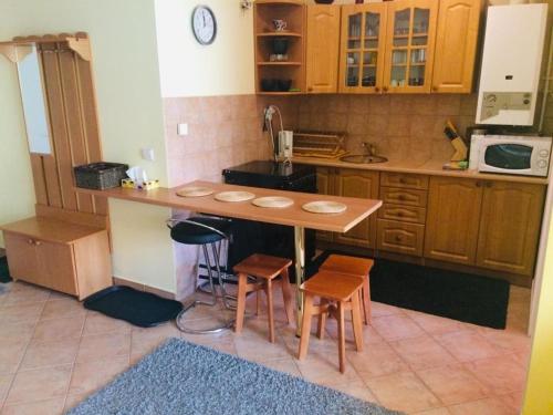 una cocina con una mesa y dos taburetes. en Apartament Eugenia, en Krynica-Zdrój