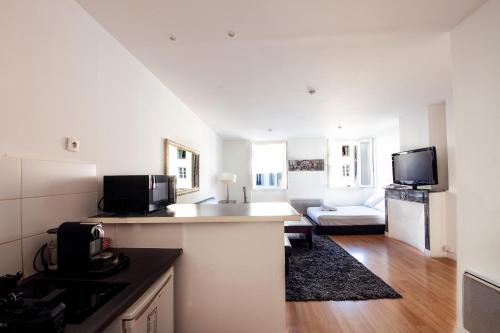 un salon avec une cuisine et un salon avec un canapé dans l'établissement Studio, à Marseille