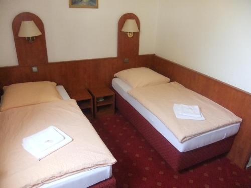 2 Betten in einem kleinen Zimmer mit in der Unterkunft Hotel Adriatic in Hannover